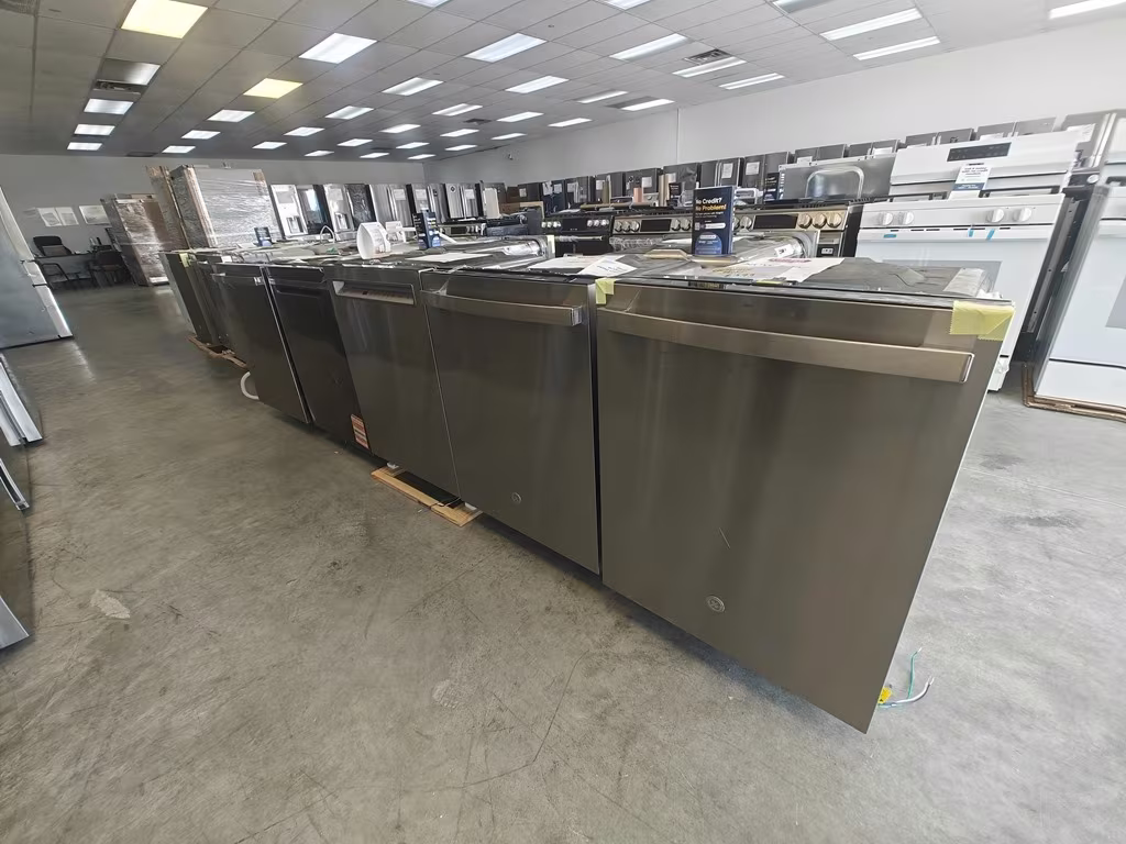 A row of stainless dishwashers on pallets
